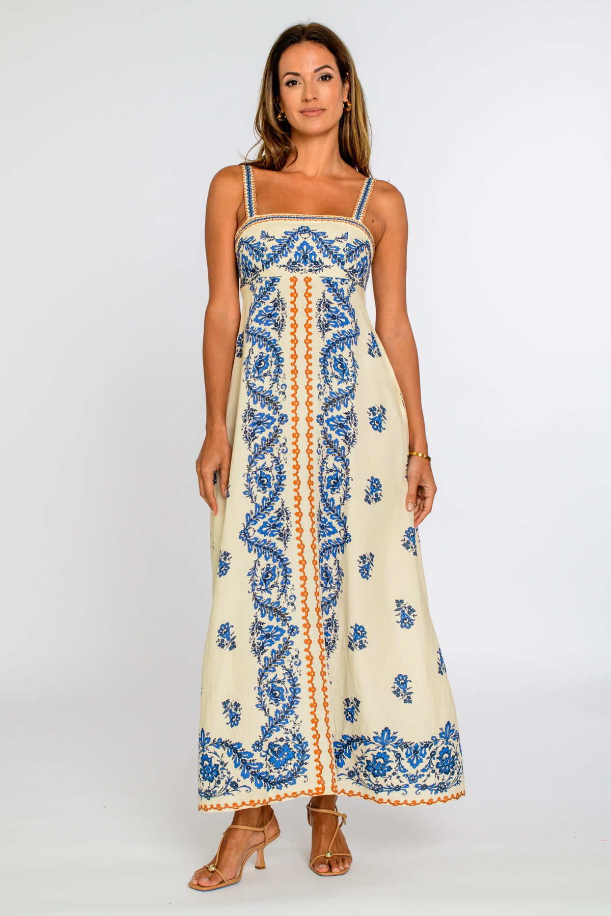 Woman wearing a long, patterned dress on a white background