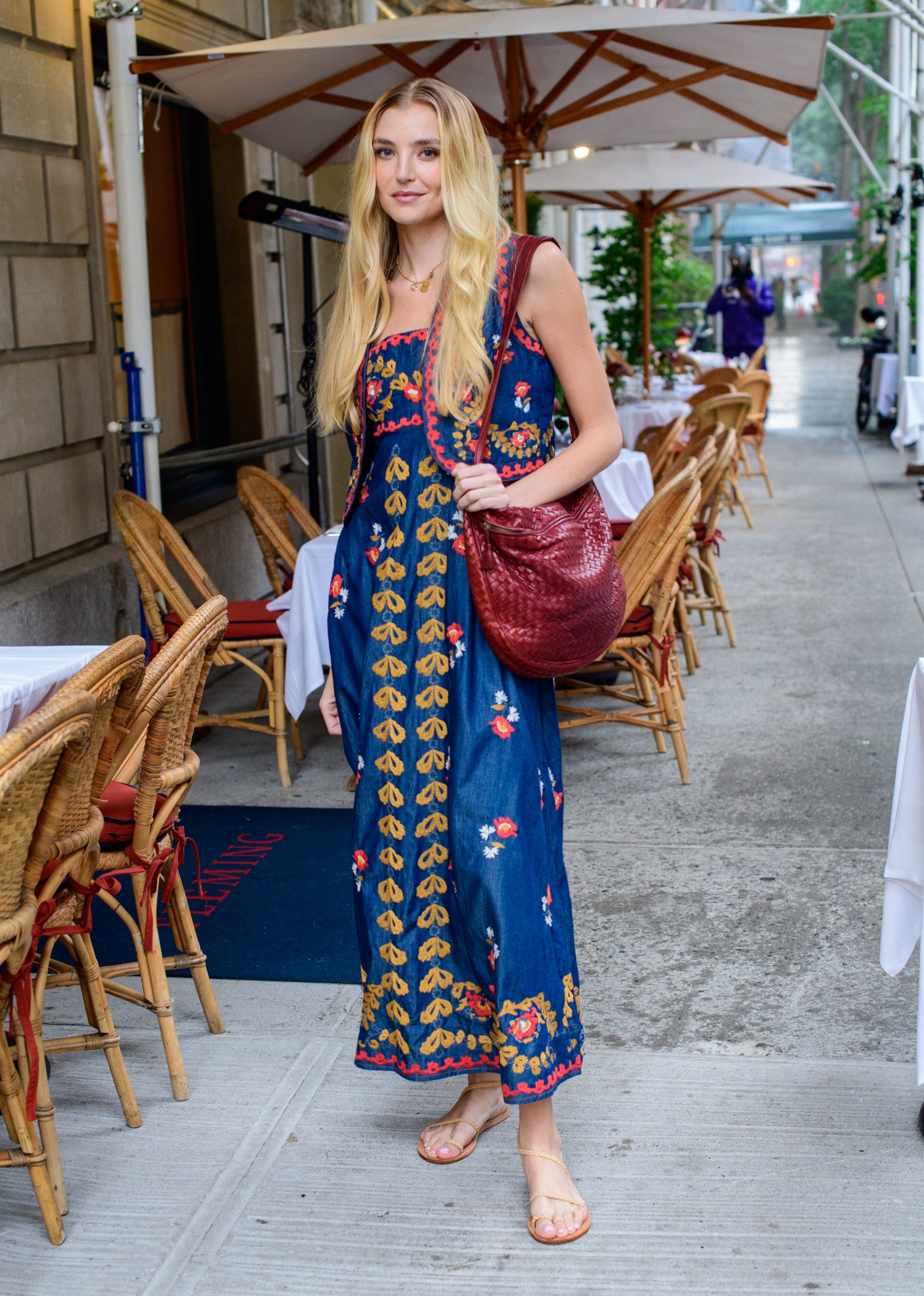 Woman in a floral dress standing in an outdoor dining area